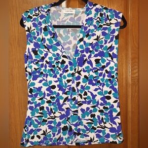 A Calvin Klein v-neck blue and purple floral pattern sleeveless boxy top.